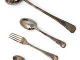 three spoons, a fork, and a spoon rest on a white surface