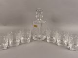 six verres et une carafe posés sur une table