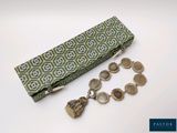 a green and white case with a bunch of coins in it
