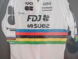 une veste blanche ornée d'une bande aux couleurs de l'arc-en-ciel