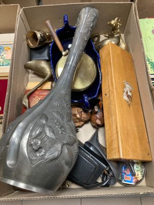 une boîte en carton remplie d'objets divers, comme des cuillères, des cuillères et d'autres objets