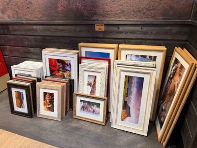 a lot of picture frames on a table in a room