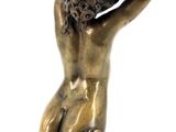 bronze statue of a woman sitting on a stool with her hands on her head