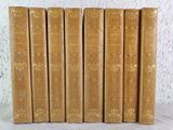 six vieux livres sont alignés sur une table