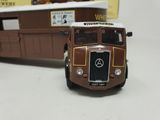 a toy bus that is sitting next to a box car