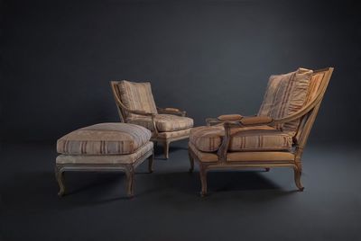 two chairs and a ottoman in a dark room with a black background