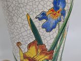 a white vase with a blue and yellow flower on it