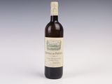 an old bottle of wine sitting on top of a white table
