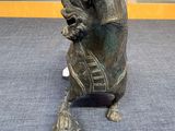 bronze statue of a horse with a bell in its mouth