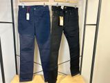 un jean noir et un jean bleu suspendus à un portant dans un magasin de vêtements