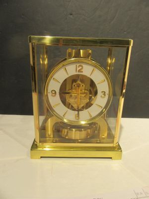 une horloge en or posée sur une table blanche
