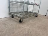 a large metal cage with wheels in a room