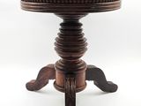 un vieux tabouret sur lequel est posé un coussin rouge
