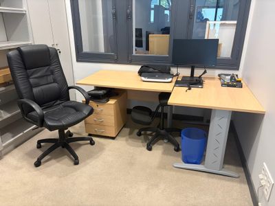 a desk with a computer and a chair in a room