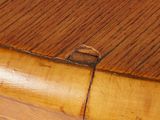 a close up of a wooden table with a hole in it