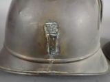 a silver helmet with a metal handle on a table