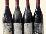 four bottles of wine are lined up in a row on a table