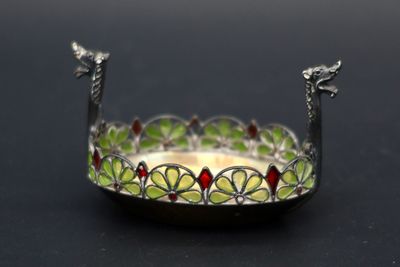 un plateau en argent orné d'un motif vert et rouge