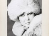 an old black and white photo of a woman wearing a fur hat