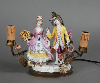 une figurine représentant un homme et une femme tenant un candélabre