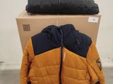 Deux vestes sont empilées sur une boîte en carton dans un entrepôt