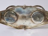 an antique silver plated belt with three circular mirrors on it