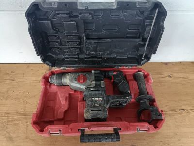 une image représentant une boîte à outils rouge contenant des outils, posée sur une table en bois