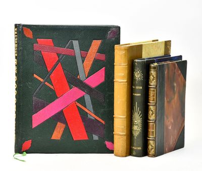 trois livres posés l'un à côté de l'autre sur une surface blanche