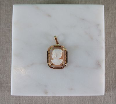 an image of a gold pendant with a cameo of a woman on it