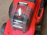 a red lawn mower that is sitting on the ground