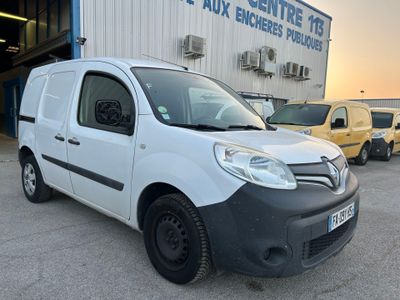la petite camionnette blanche est garée devant un bâtiment