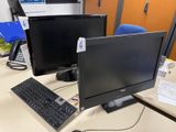 a desk with two monitors and a keyboard on it