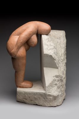 une image représentant une sculpture d'une personne appuyée contre un rocher