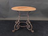 une petite table ronde avec un plateau en bois posé sur un piètement noir
