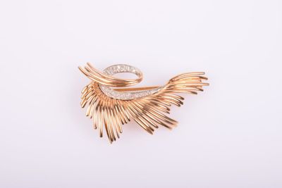 une image d'une broche en or et diamants sur fond blanc