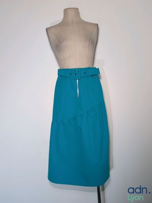 une jupe bleue posée sur un mannequin, sur fond blanc