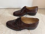 pair of brown leather shoes with laces on them on a marble floor