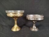 pair of silver plated bowls on pedestals on a black background