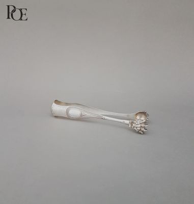 une cuillère en argent et un repose-cuillère posés sur une table