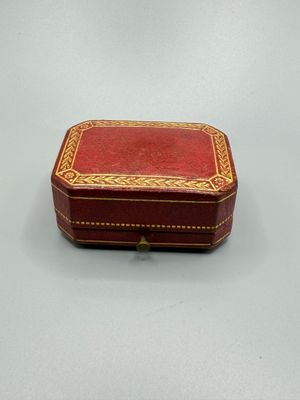 une petite boîte rouge ornée d'une bordure dorée