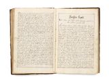 un livre ouvert avec une écriture dessus, posé sur une table