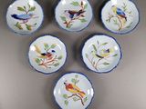 six assiettes bleues et blanches ornées d'oiseaux, posées sur une table