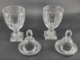 three glass goblets and a cup on a black surface