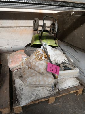 a pile of garbage on a pallet in a garage