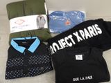 un tas de vêtements et un t-shirt posés sur un canapé