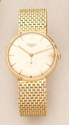 a close up of a gold wrist watch on a white surface