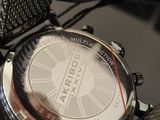 a close up of a watch with a chain around it