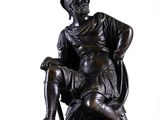 statue of a woman sitting in a chair on a white background