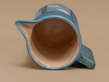 a blue and white cup with a cat on the inside of it