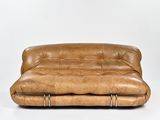canapé en cuir marron avec des pieds et des accoudoirs en métal, sur fond blanc